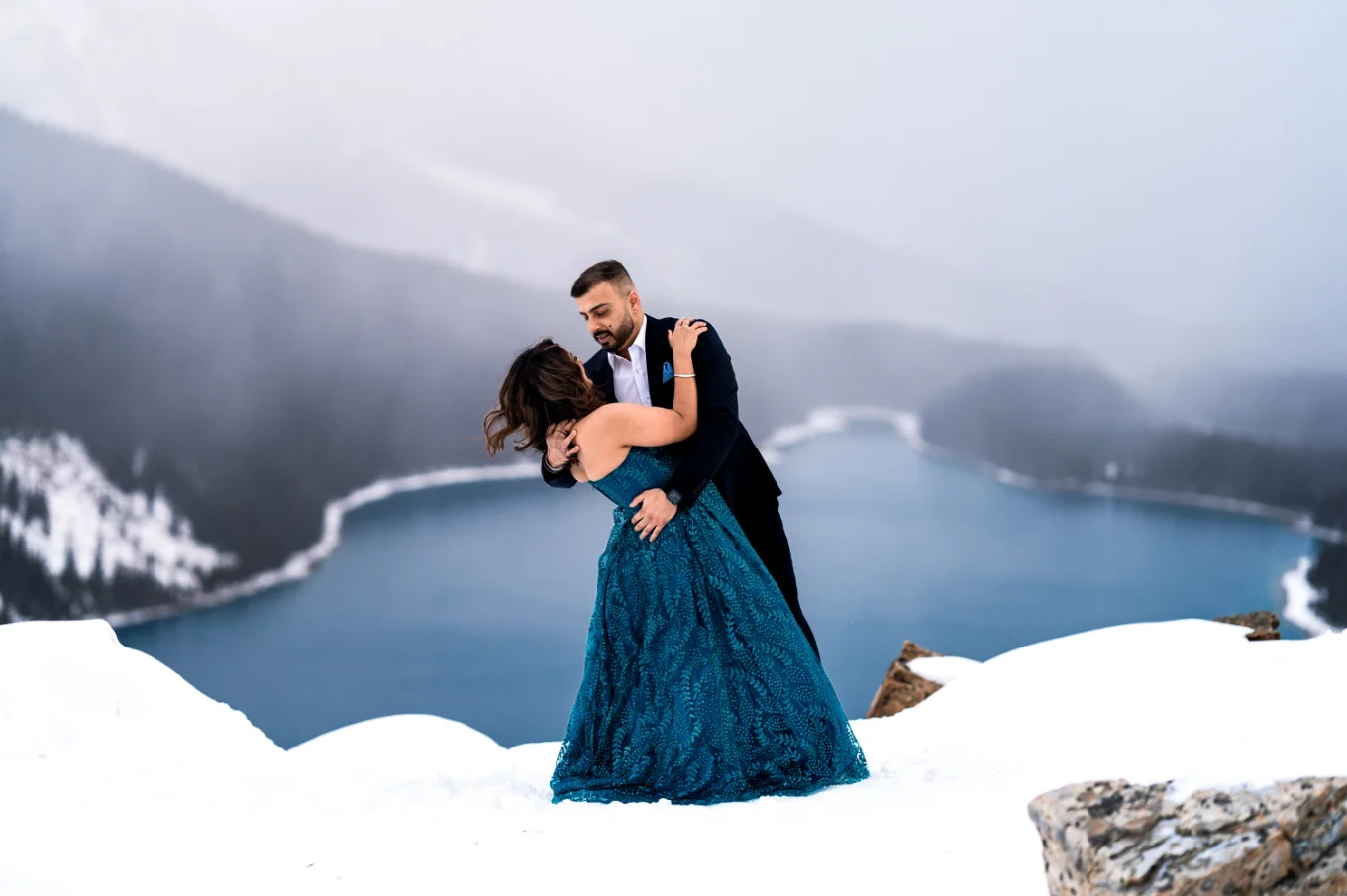 Well dressed engaged couple dance at Payto Lake during winter.