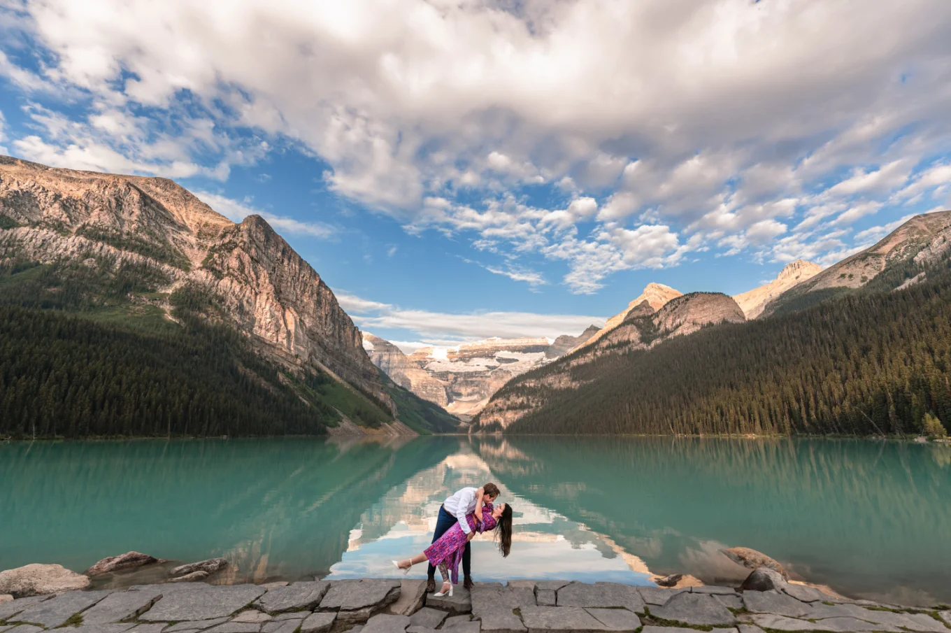 Dancing couple at stunning Lake Luoise against the rocky Mountains