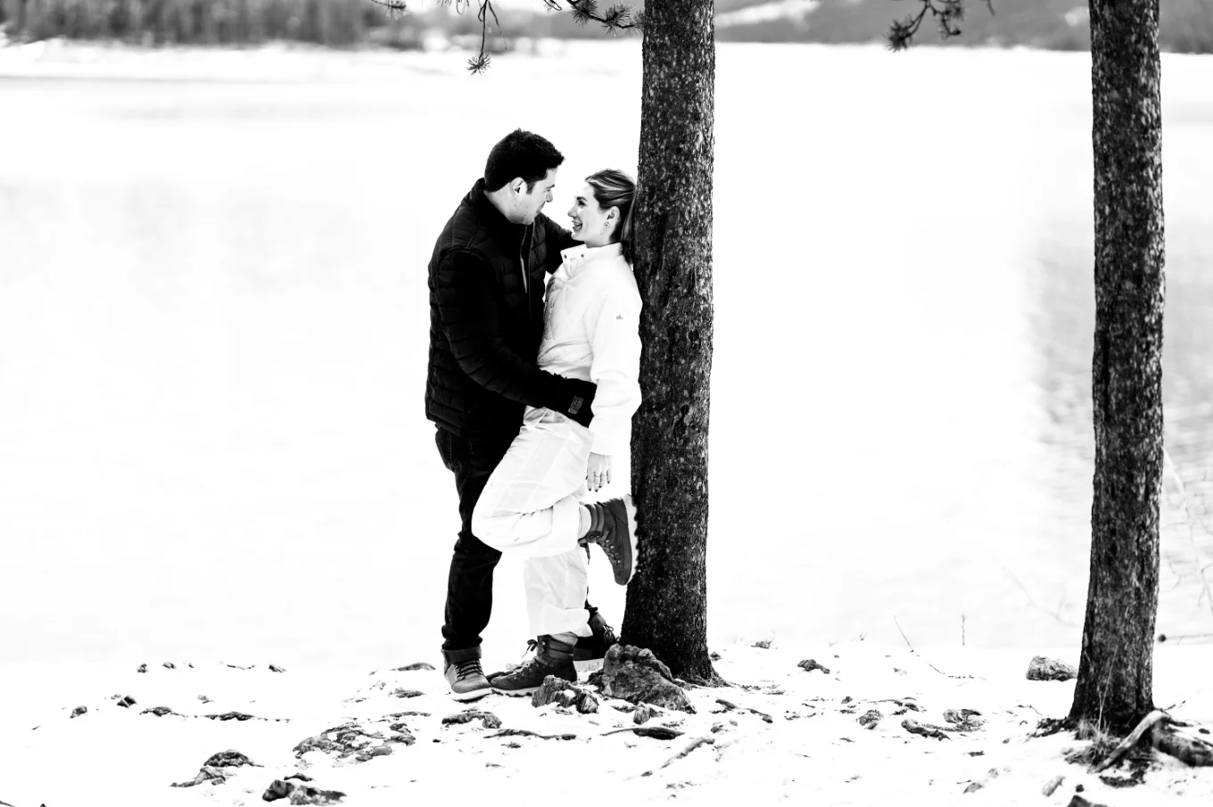 Banff lovers lean over the tree and hug