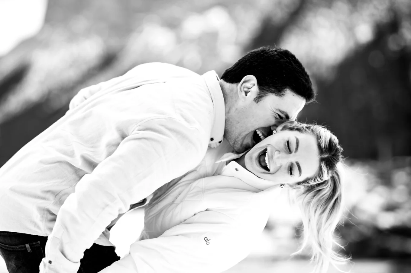 A man tries to bite his fiancees neck. She laughs.