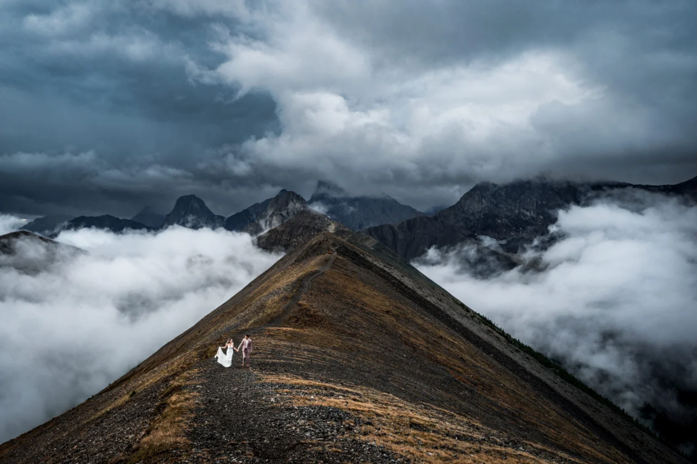 Bride and groom walk on the ridge