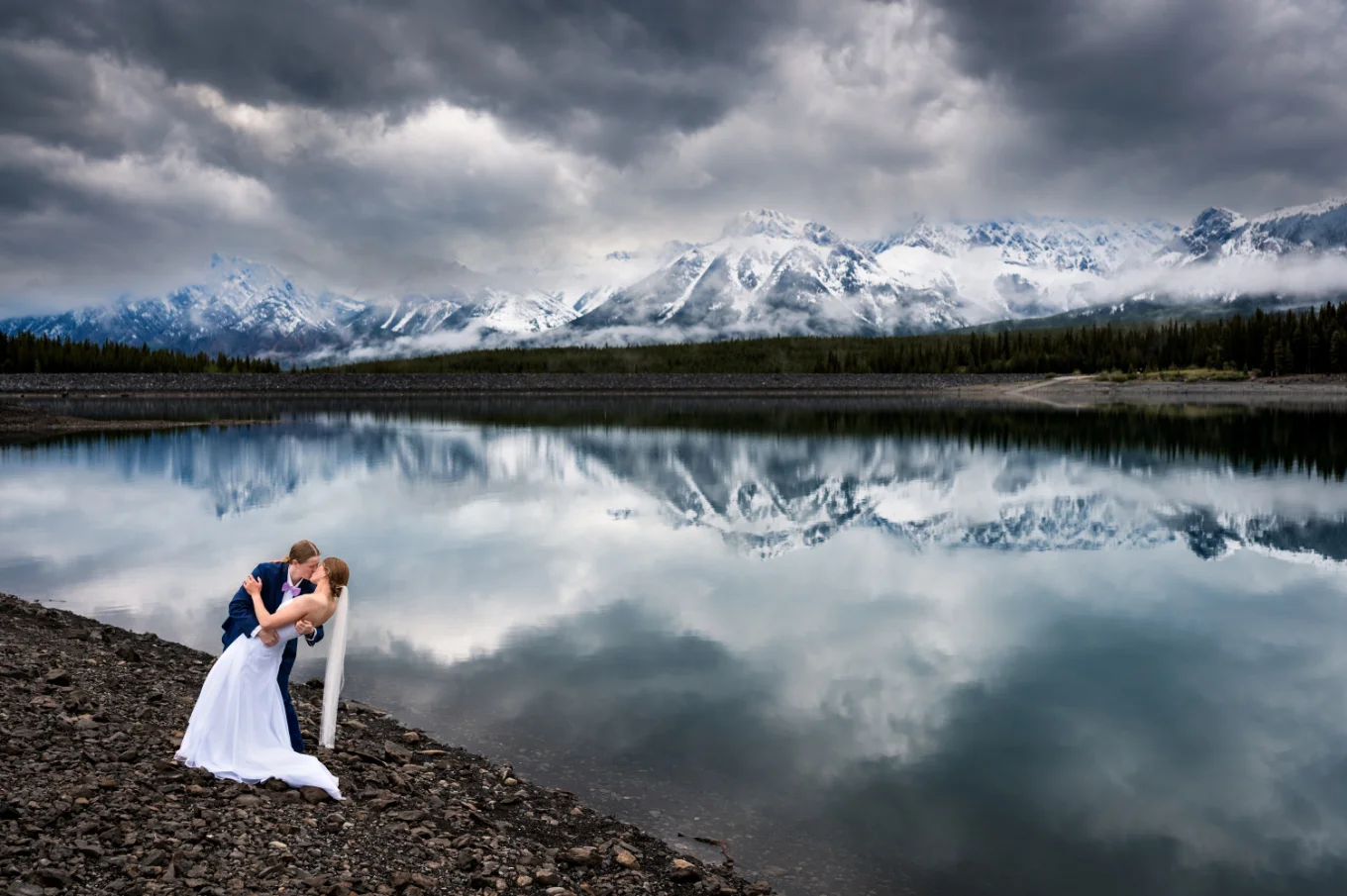 Two brides kiss at the lakeshore