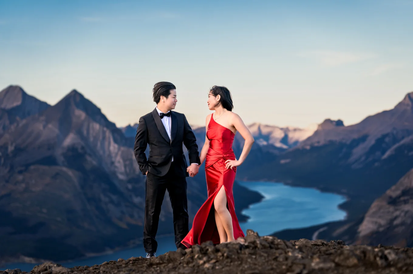 Newlyweds pose on the top of the mountain