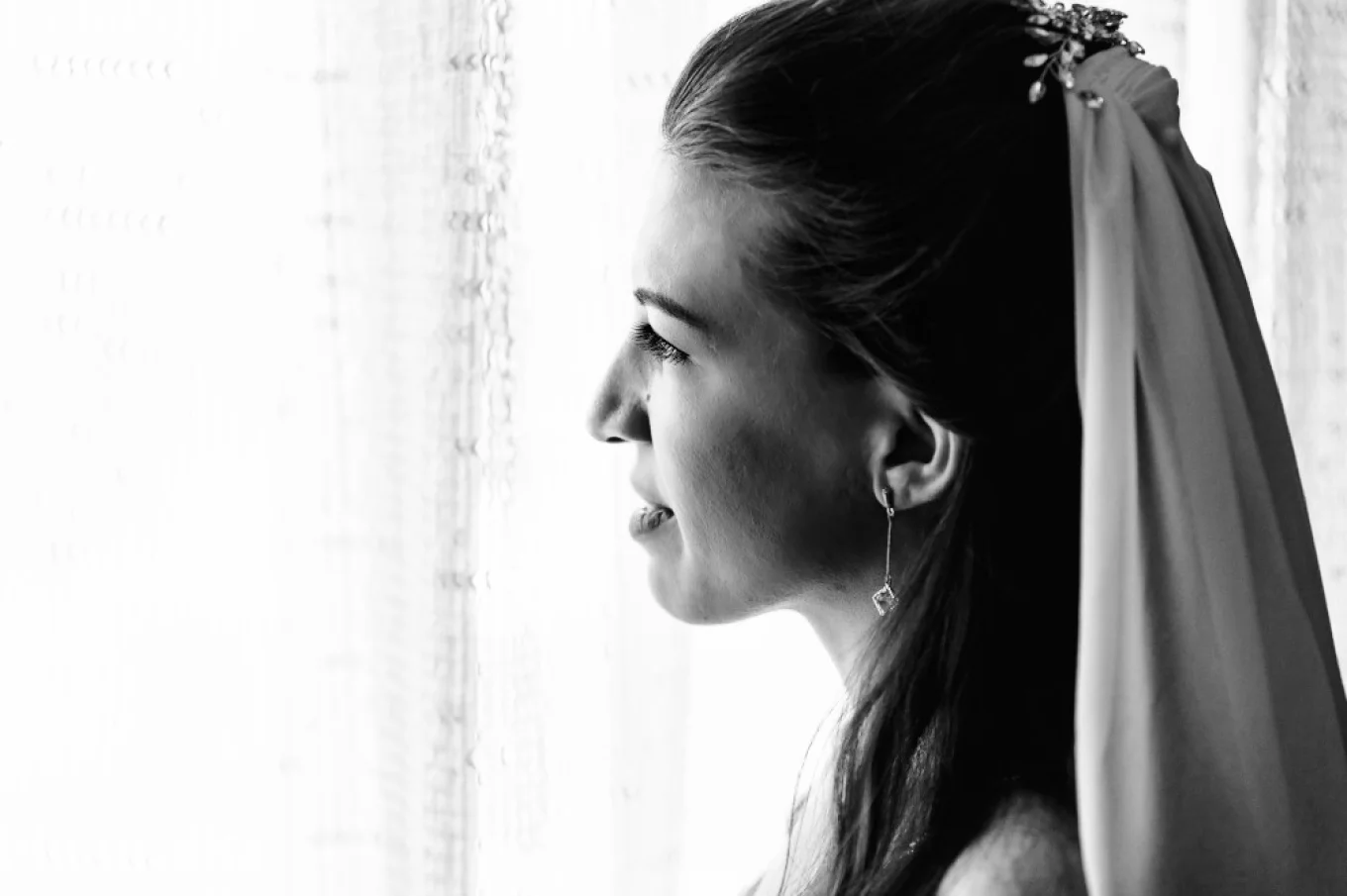 Bride looks through the window before wedding ceremony in Banff