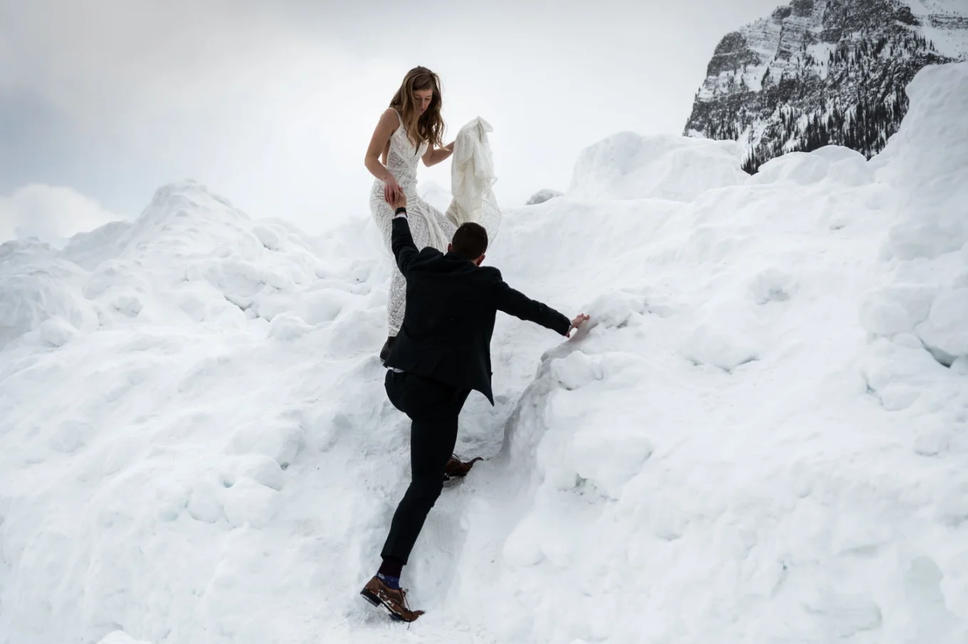 Newlyweds are climbing the mountain in Banff