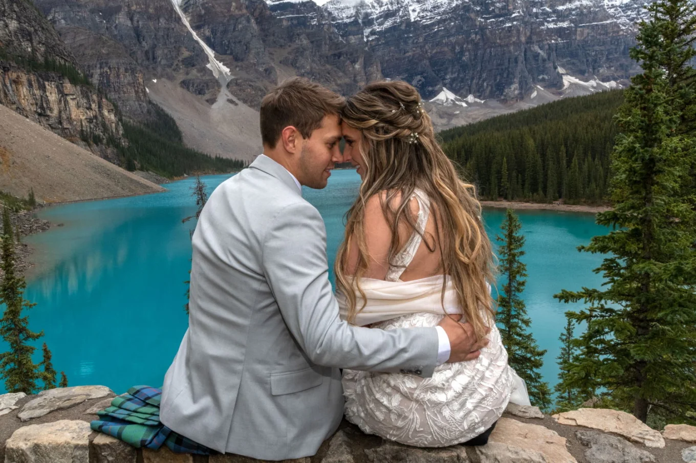 Groom and bride in intimate moment while touching foreheads and looking at each other