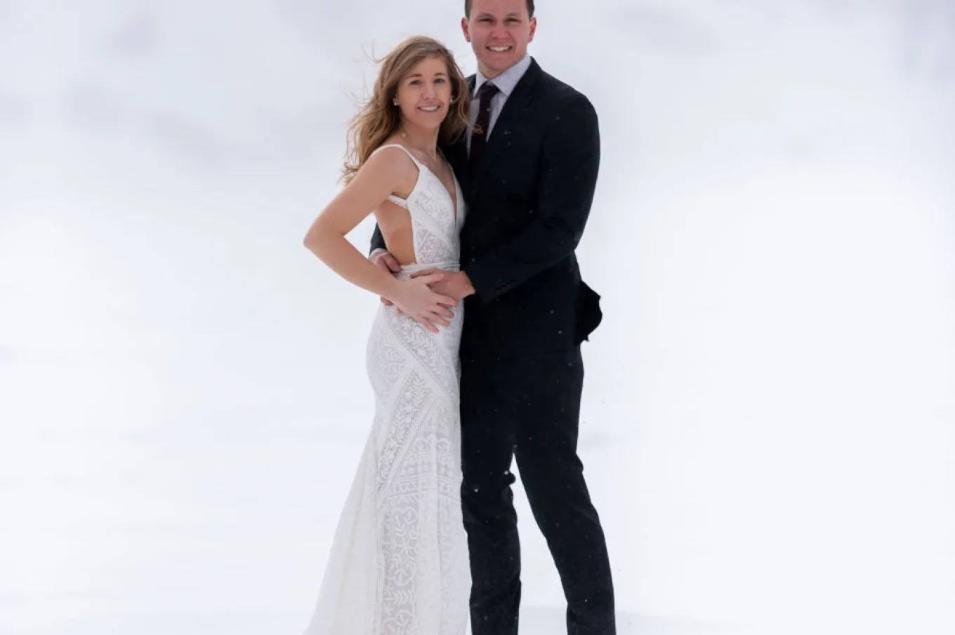 Newlyweds are posing and smiling at the camera during wedding photo session in Banff.
