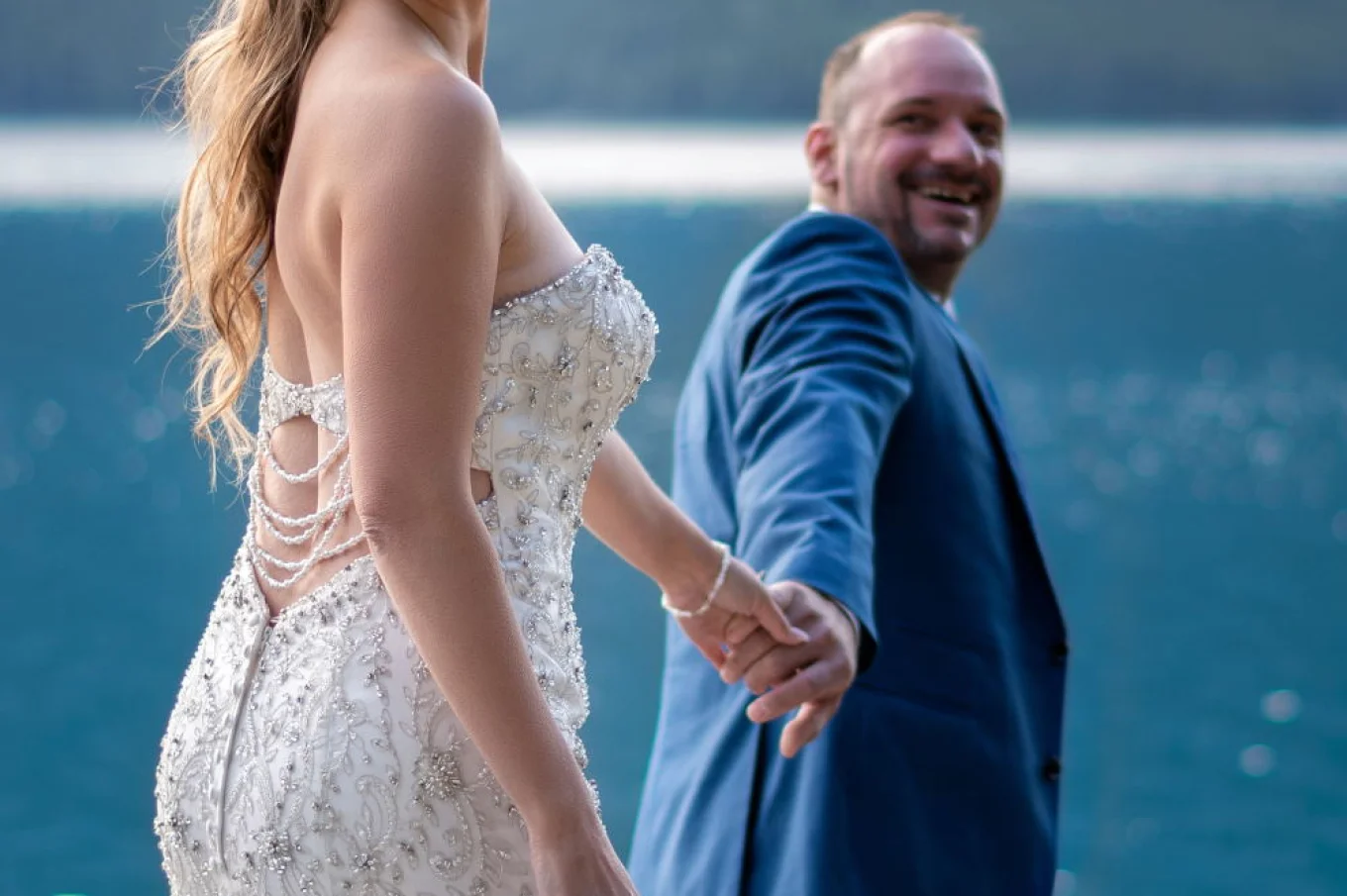 Groom leads his bride by hand during Banff after wedding shoot.