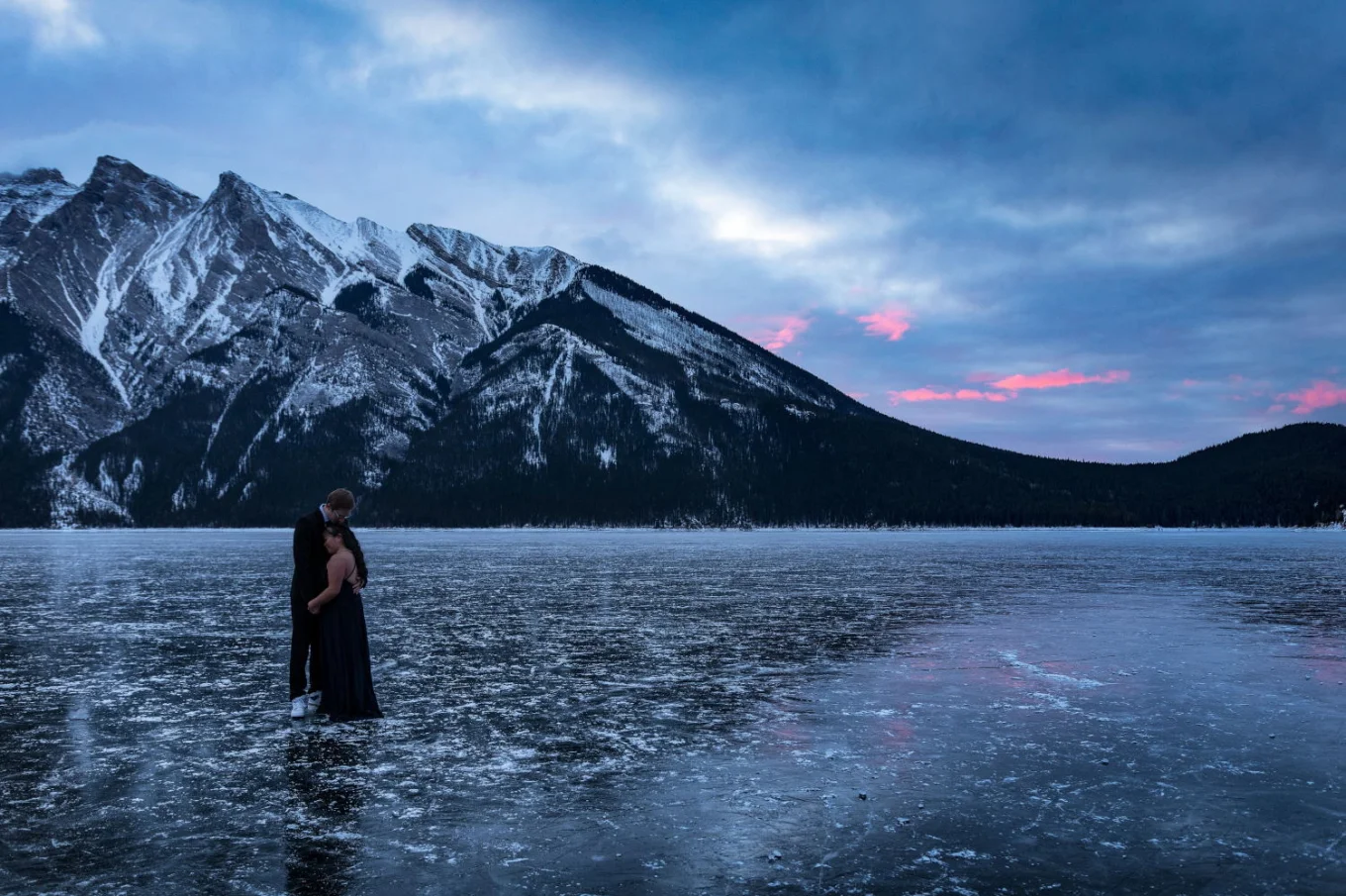 Engaged couple is hugging each other during frosty morning in Banff.