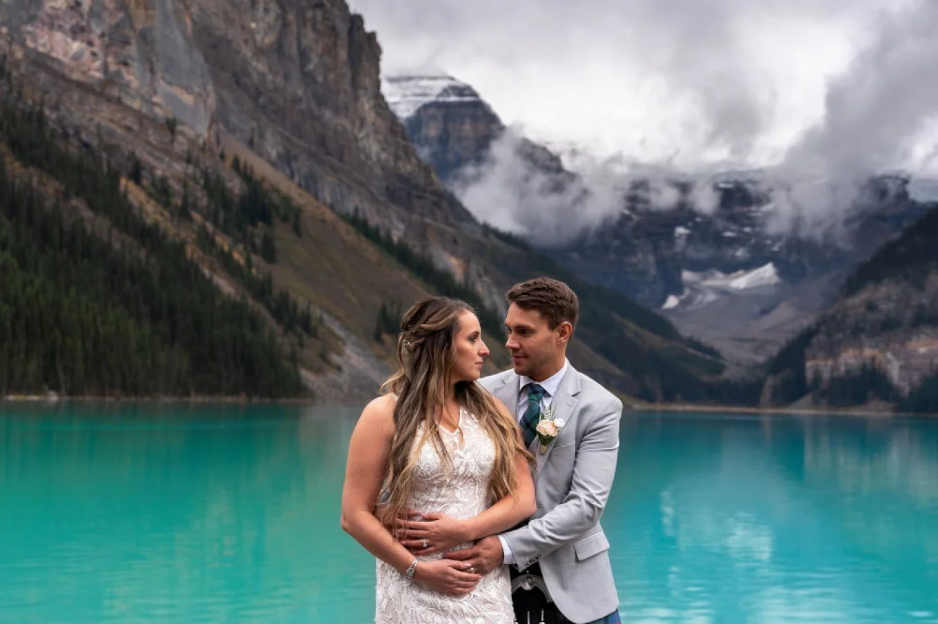 Scottish groom hugging his wife at the lake in Canadian Rocky Mountains