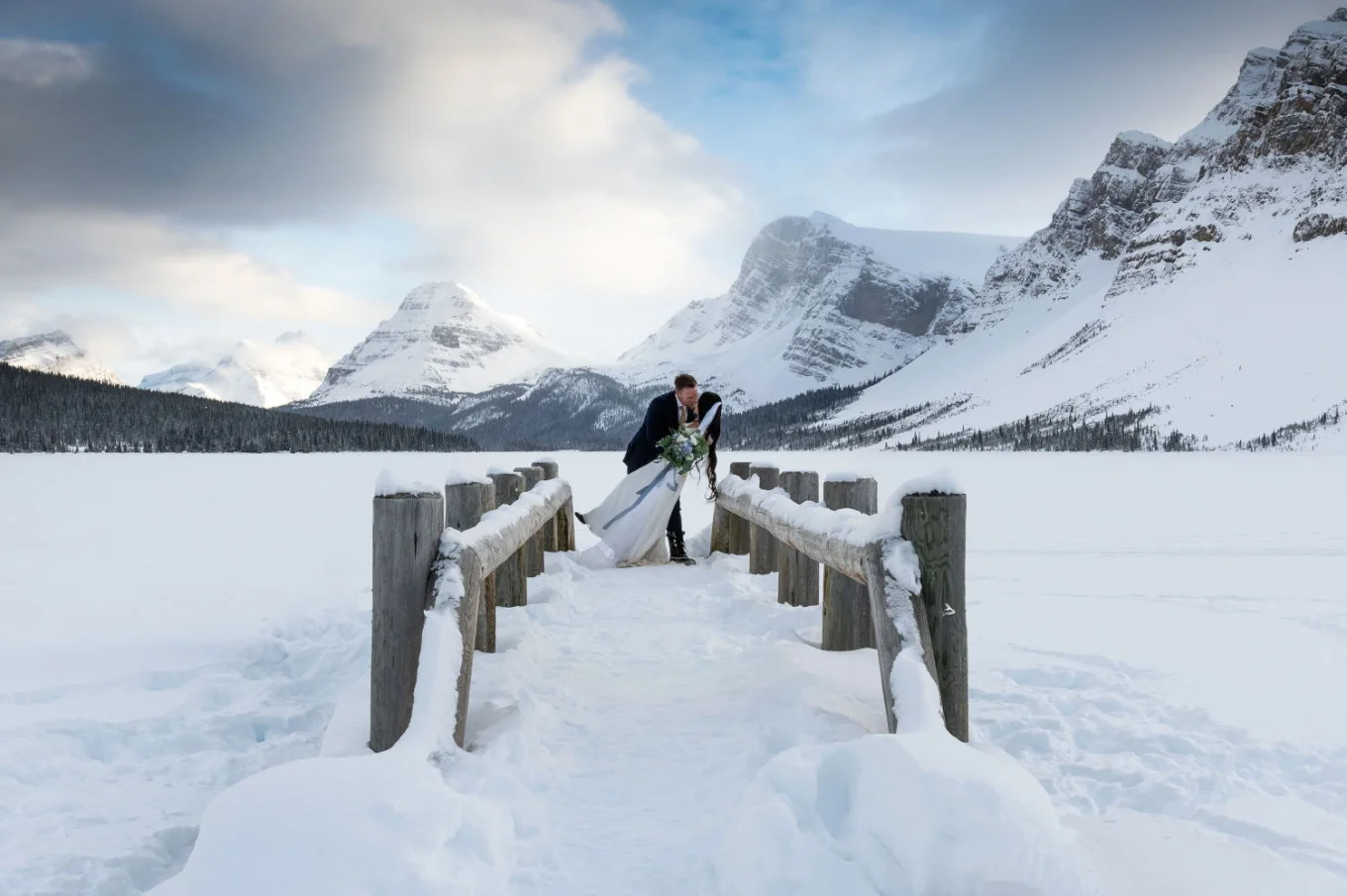 Groom are kissing the bride on the bridge after wedding ceremony in Banff.