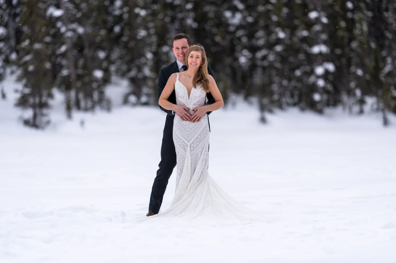 Newlyweds smiling at the camera at their wedding day at Lake Louise