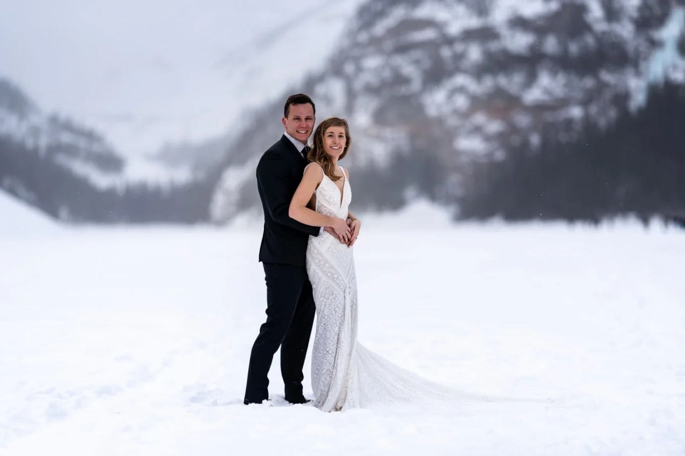 Groom hugging his new wife during wedding photo session at Lake Louise