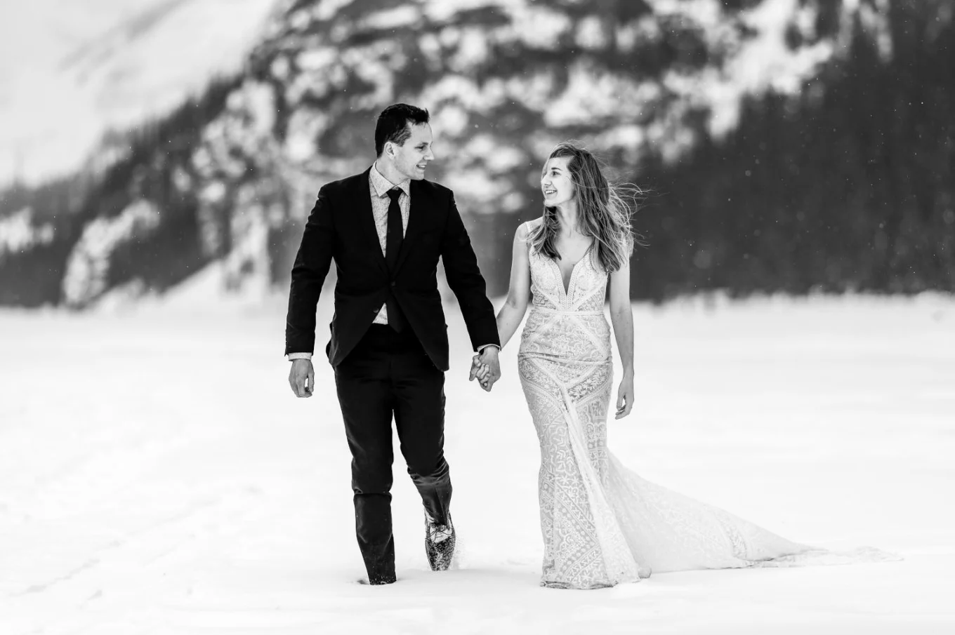 Married couple are walking during their after wedding photo session at Lake Louise