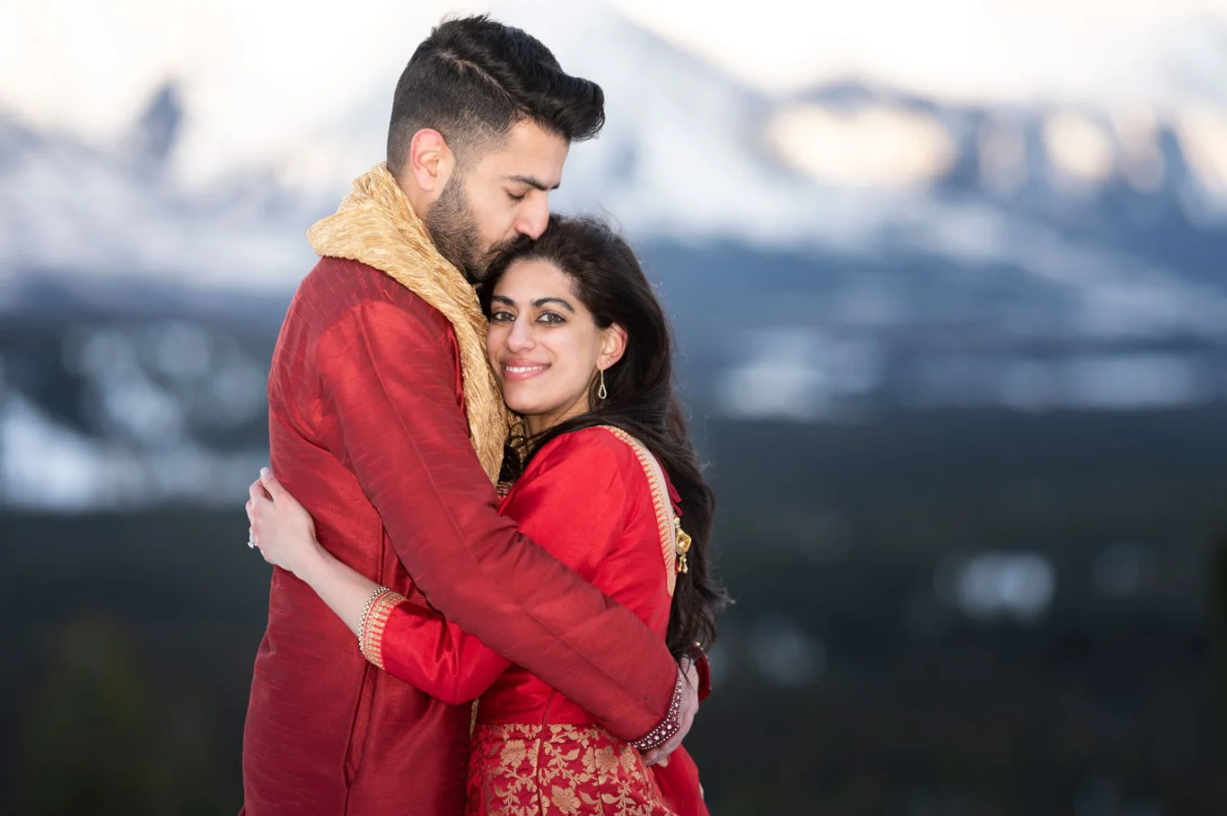Indian groom and bride hugs during after wedding photo session.