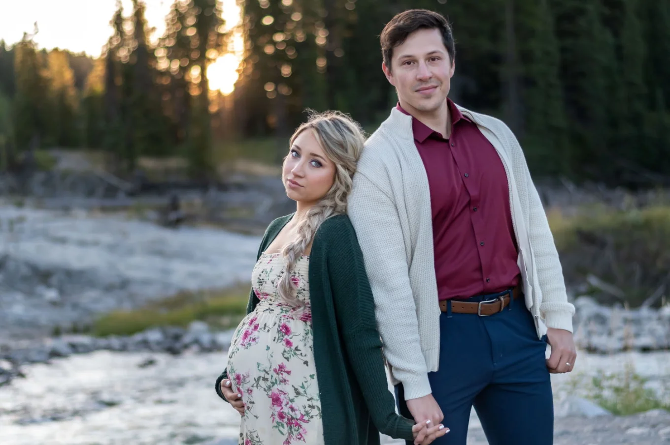 Maternity portrait in Banff. A couple celebration of their pregnancy. They smile and hold their hands.