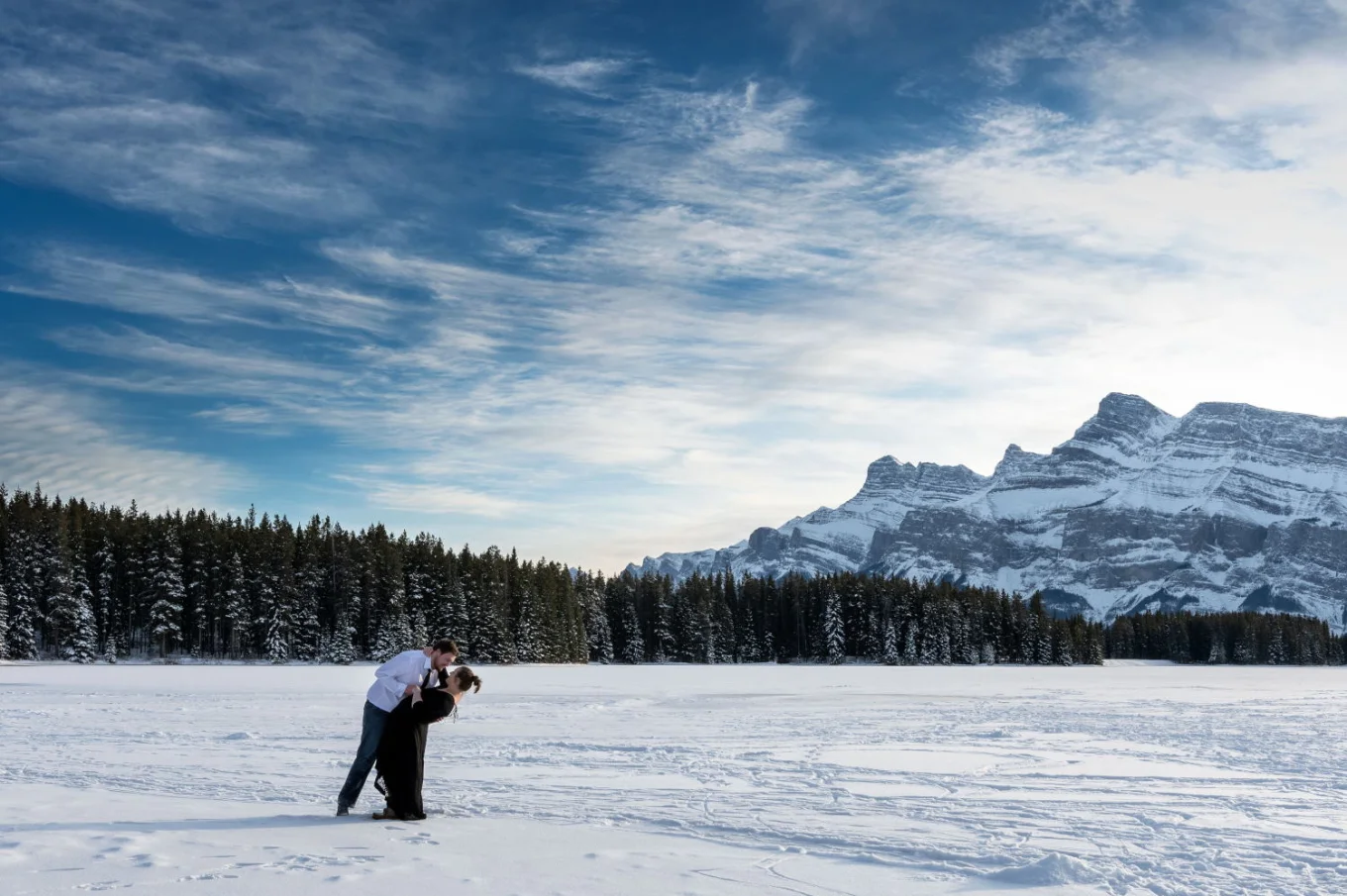 Engaged couple dancing in the snow. Banff engagement Photography.