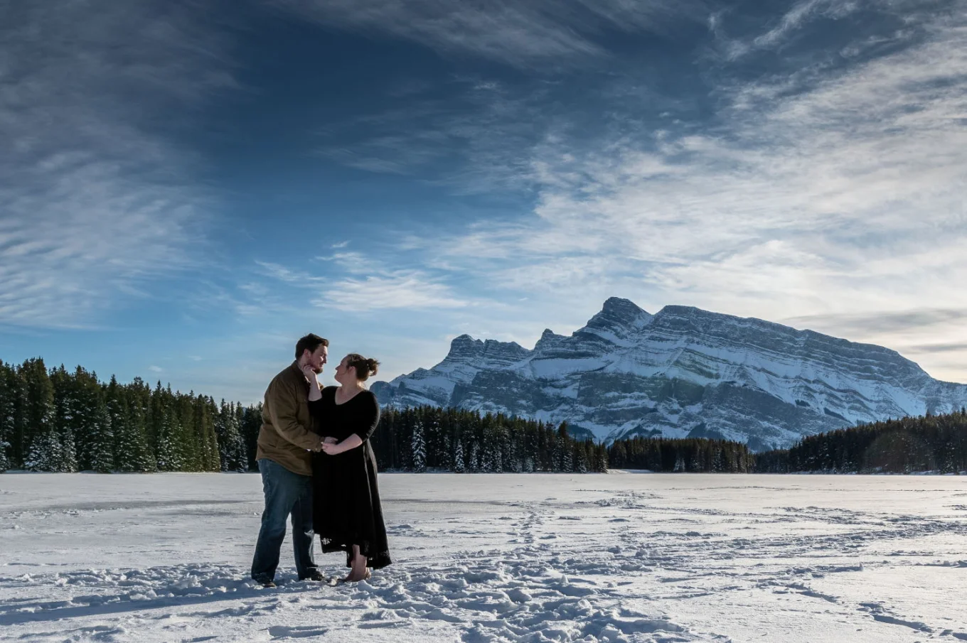 Couple in love look deaply into their eyes during winter photo session at Two Jack Lake.