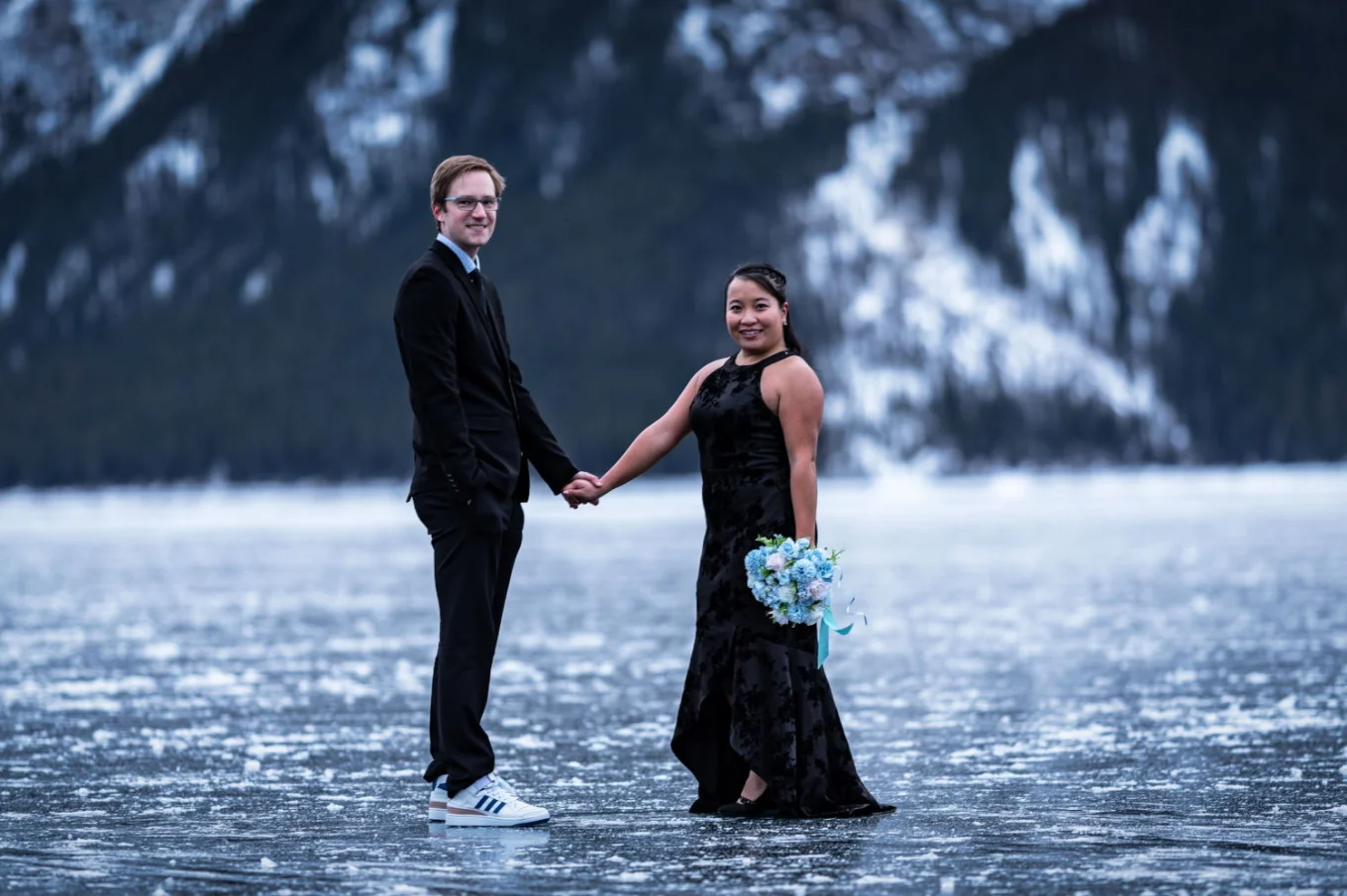 Happy couple smile at the camera during engagement photo session at Minnewanka Lake