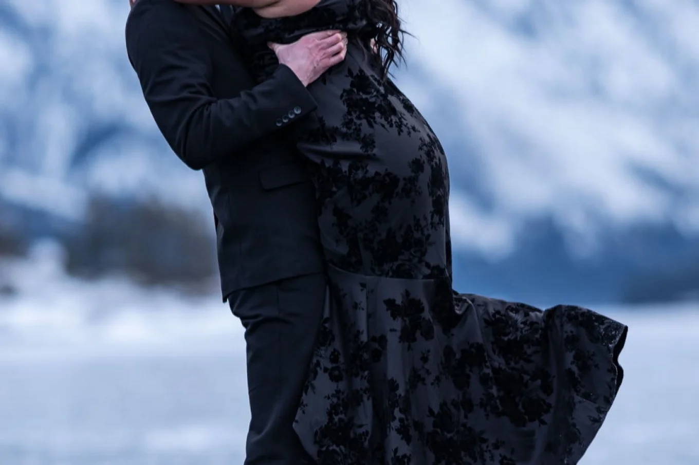 Happy fiancé is holding his future wife after his proposal. They look at each other with love.