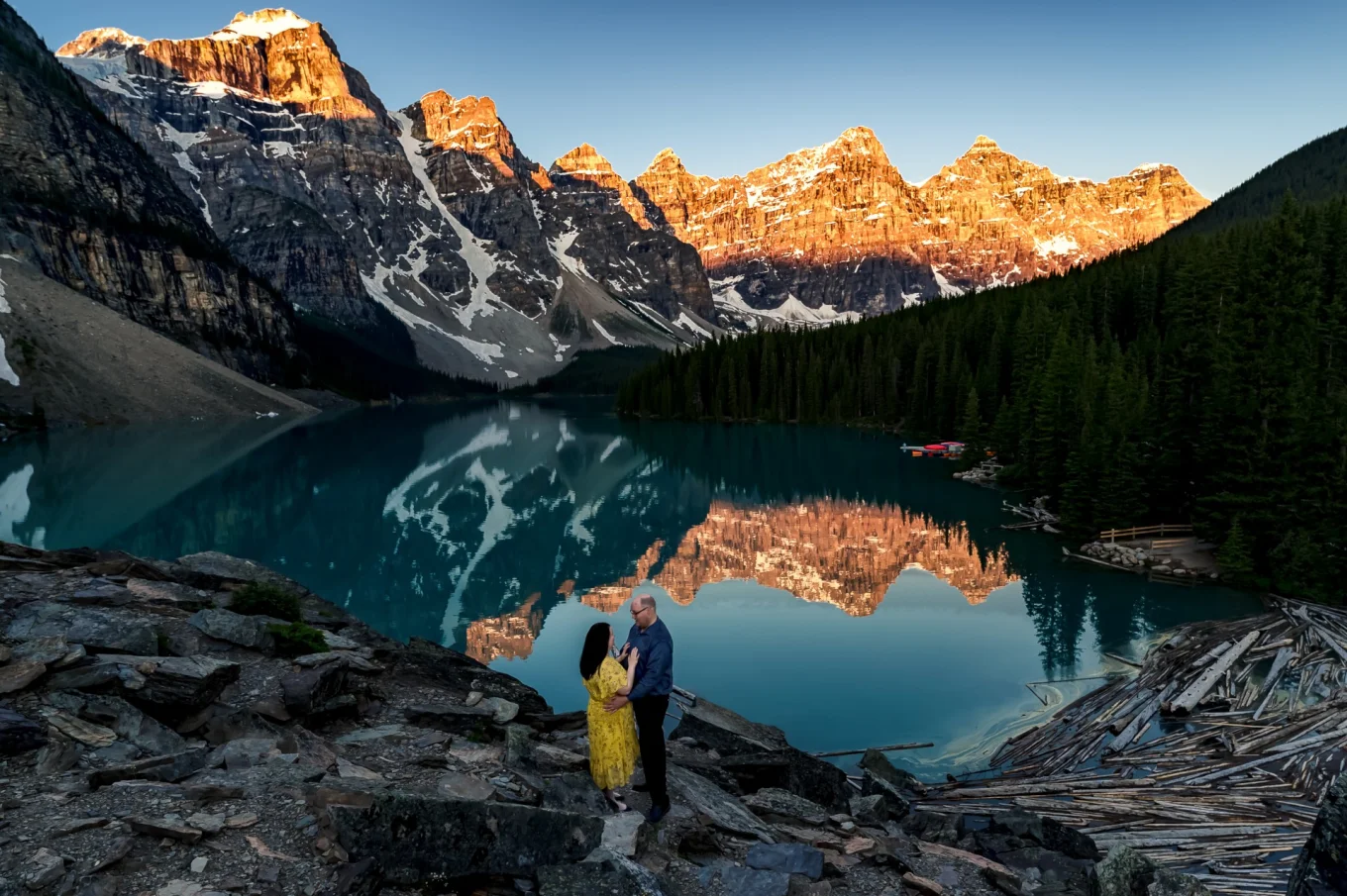 Couple in love look at the beauty of sunset at Moraine lake during their engagement photo session