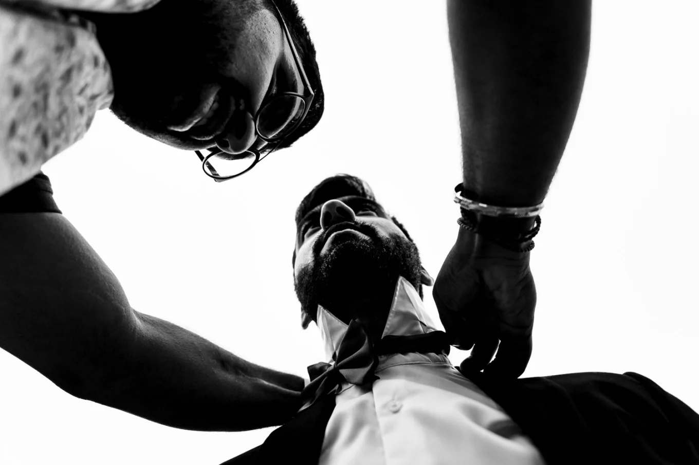 Best men is helping the groom to fix the tie