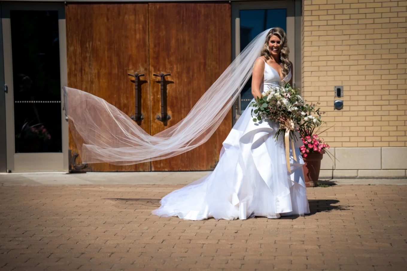 Gorgeous bride in white wedding dress is posing to be photographed by Calgary Wedding Photographers.