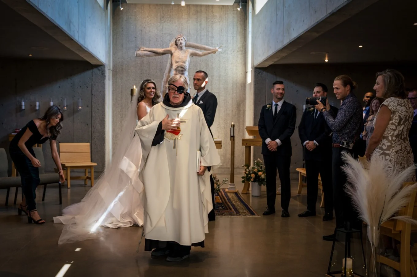 Priest and newlyweds are standing in the front of the altar during Calgary wedding