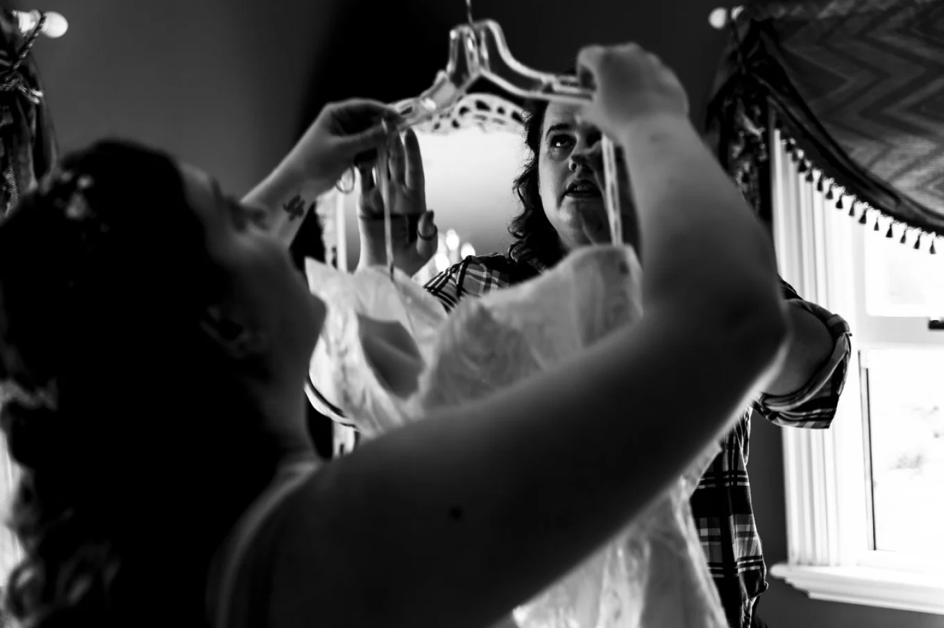 Bride is putting on a wedding dress before wedding ceremony in Calgary.