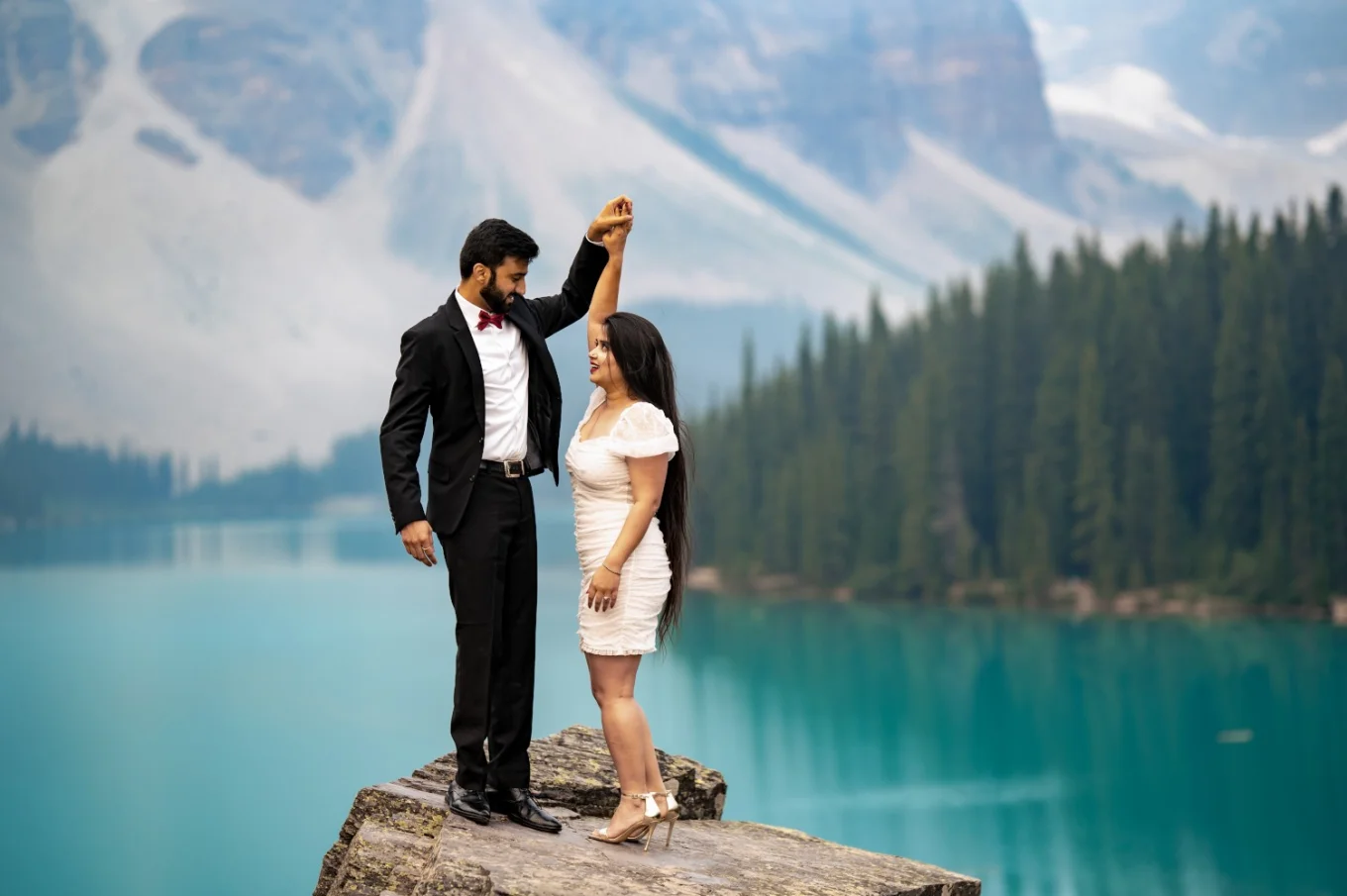 Engaged couple dandling at Moraine Lake during the sunrise.