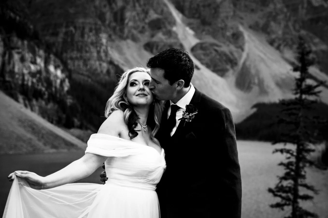 Groom kisses brides cheek.