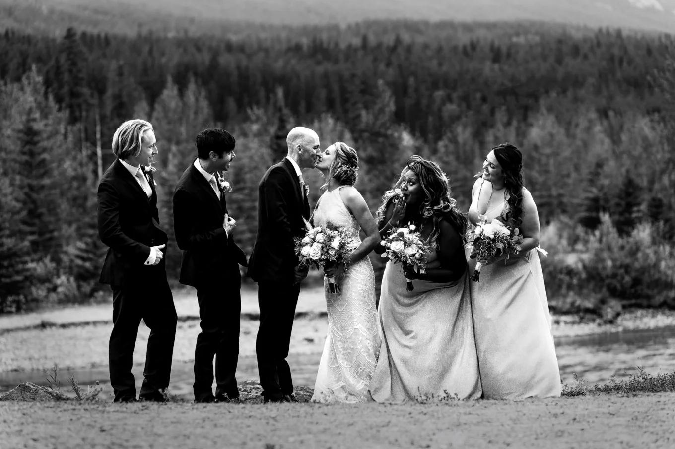 bride and groom are kissing during the bridal party
