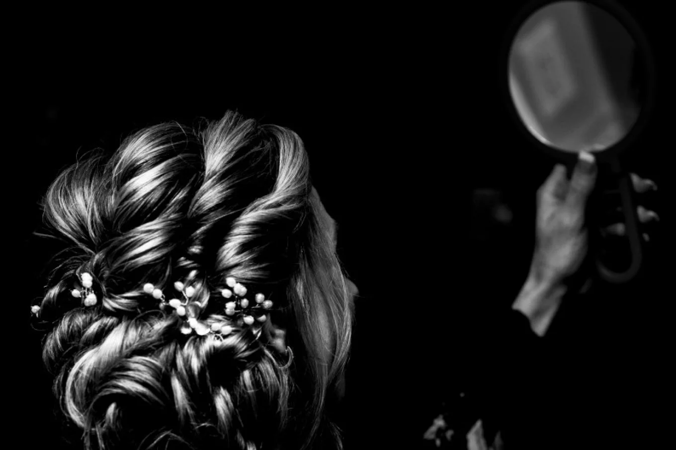bride is looking at the mirror and checking her hair before the Wedding ceremony in Calgary