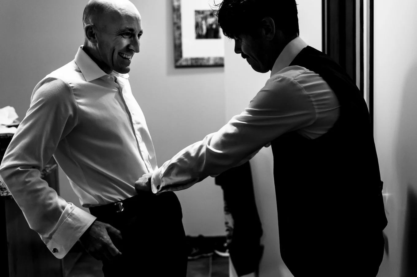The best man helping the groom to zip his panties.
