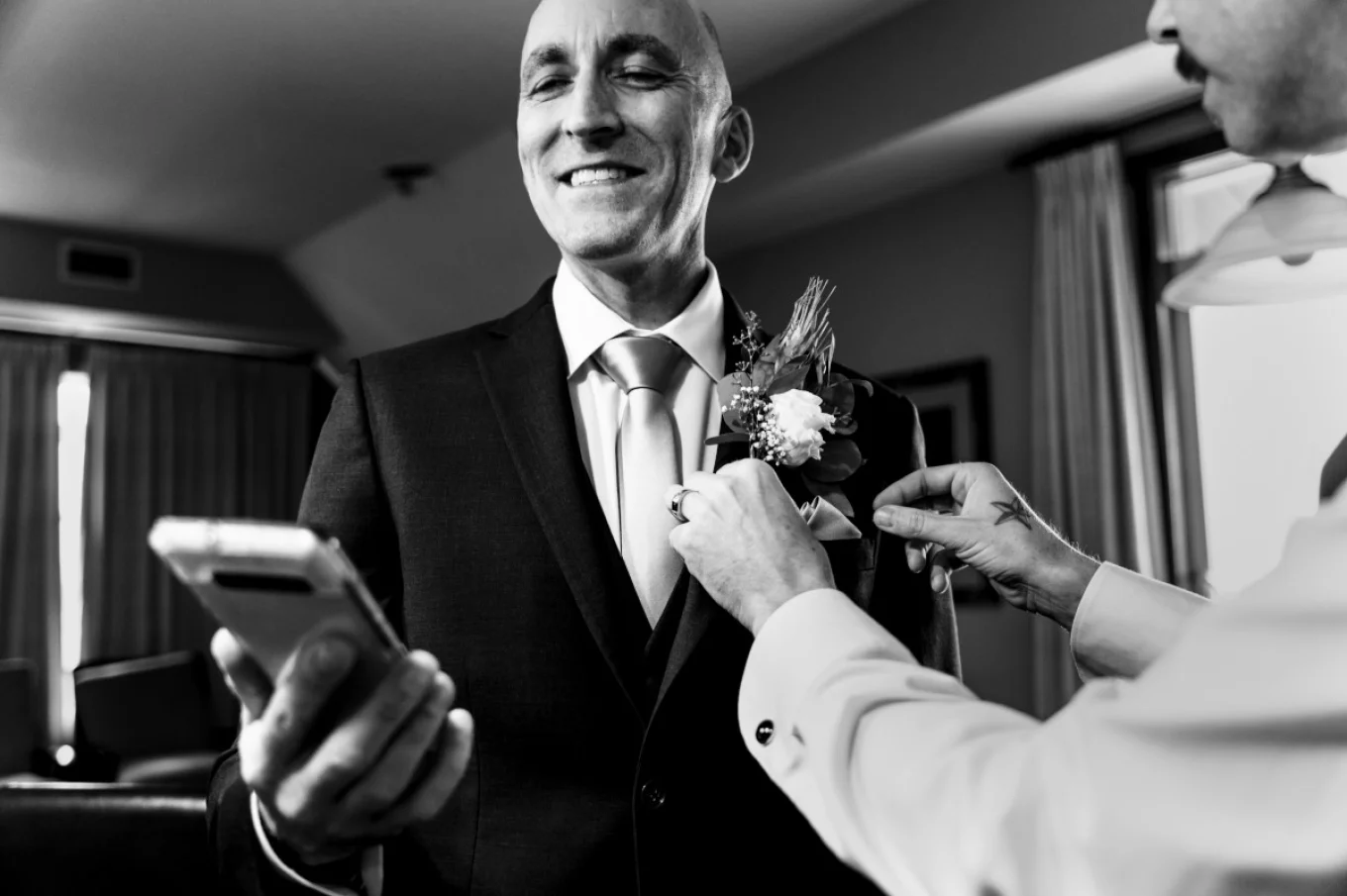 Groom looking at his cellphone and checking what time is it before Calgary wedding ceremony