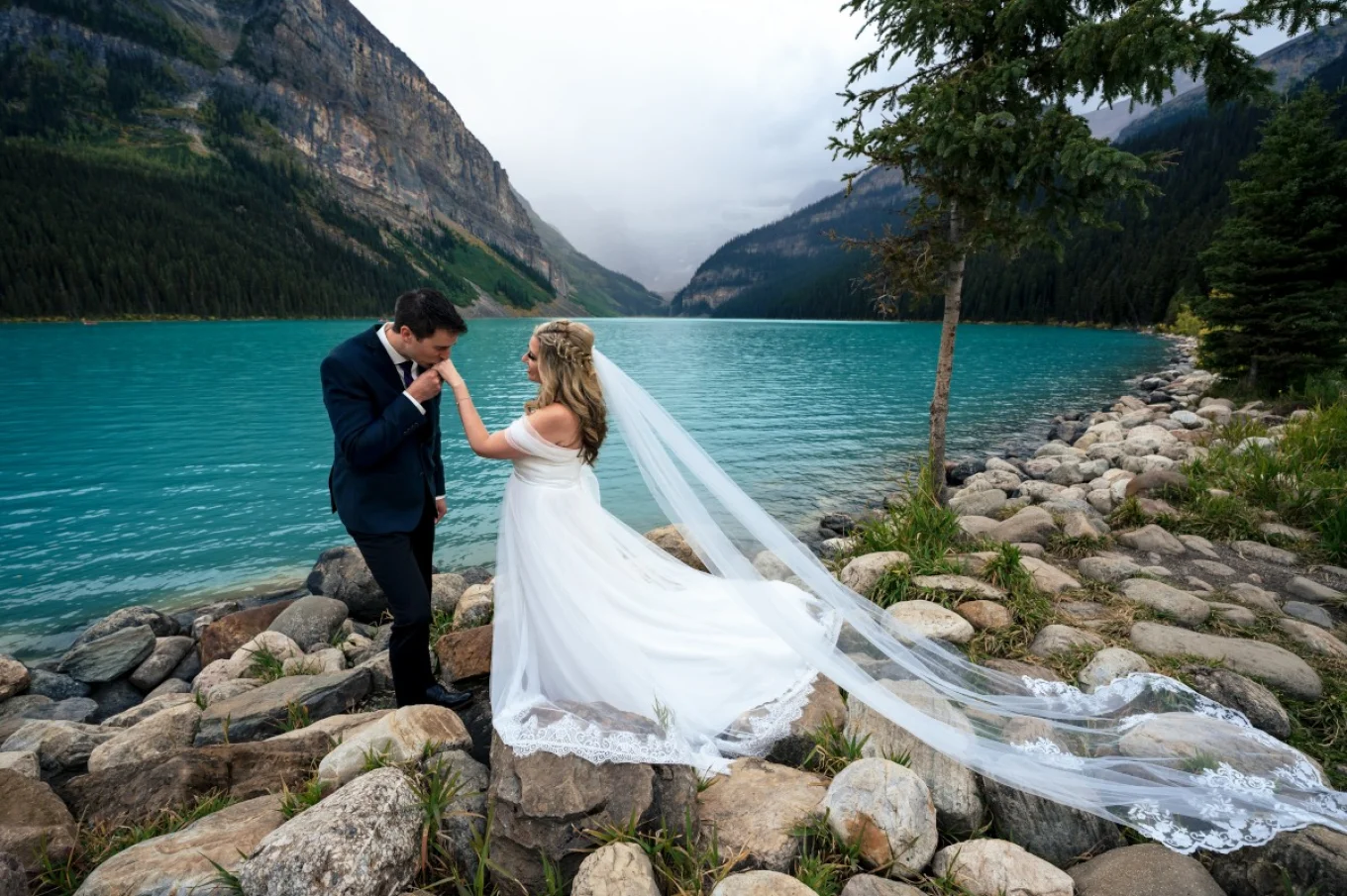 Groom kisses brides hand at Lake Louise Wedding.