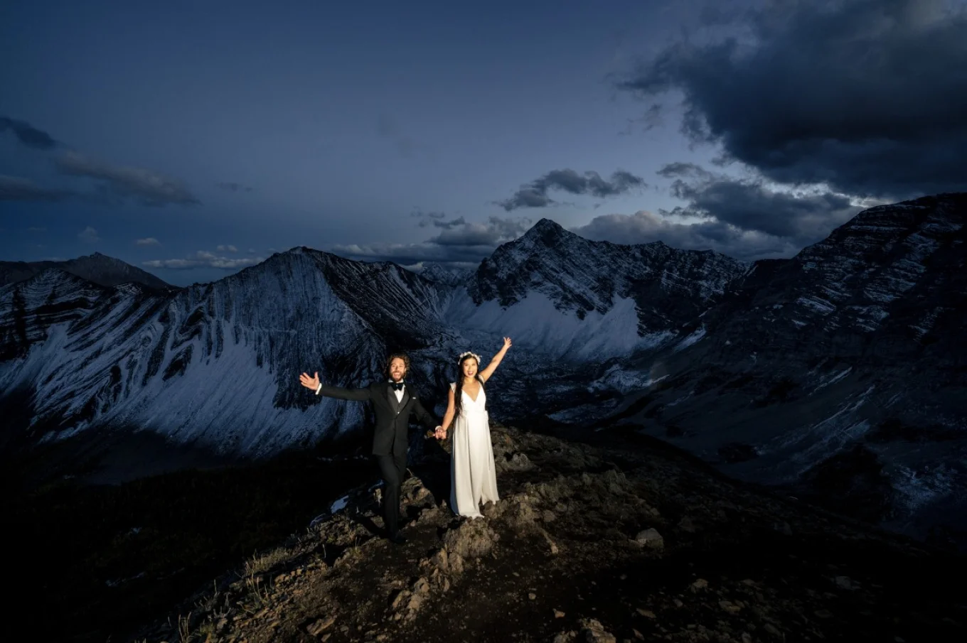 Wife and husband celebrate their love on the peak of the mountain in Banff.