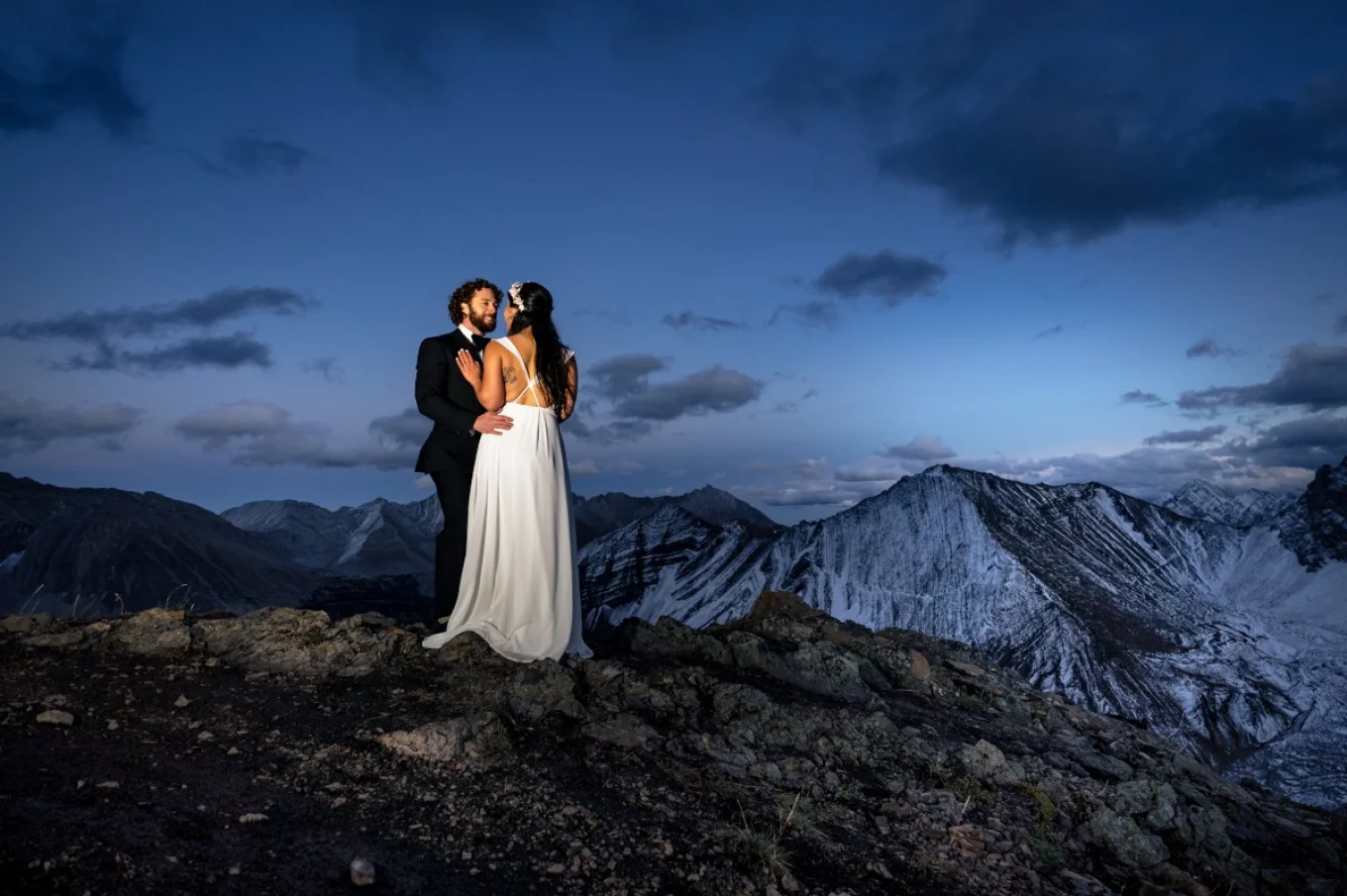 Bride and groom look at each other surrounded by the Canadian Rockies.