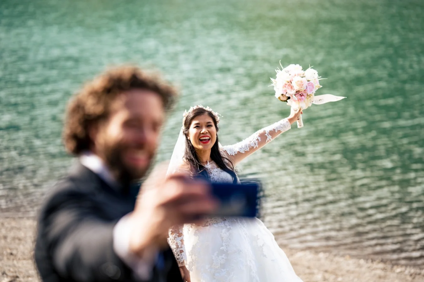 Groom is taking photos of the bride.