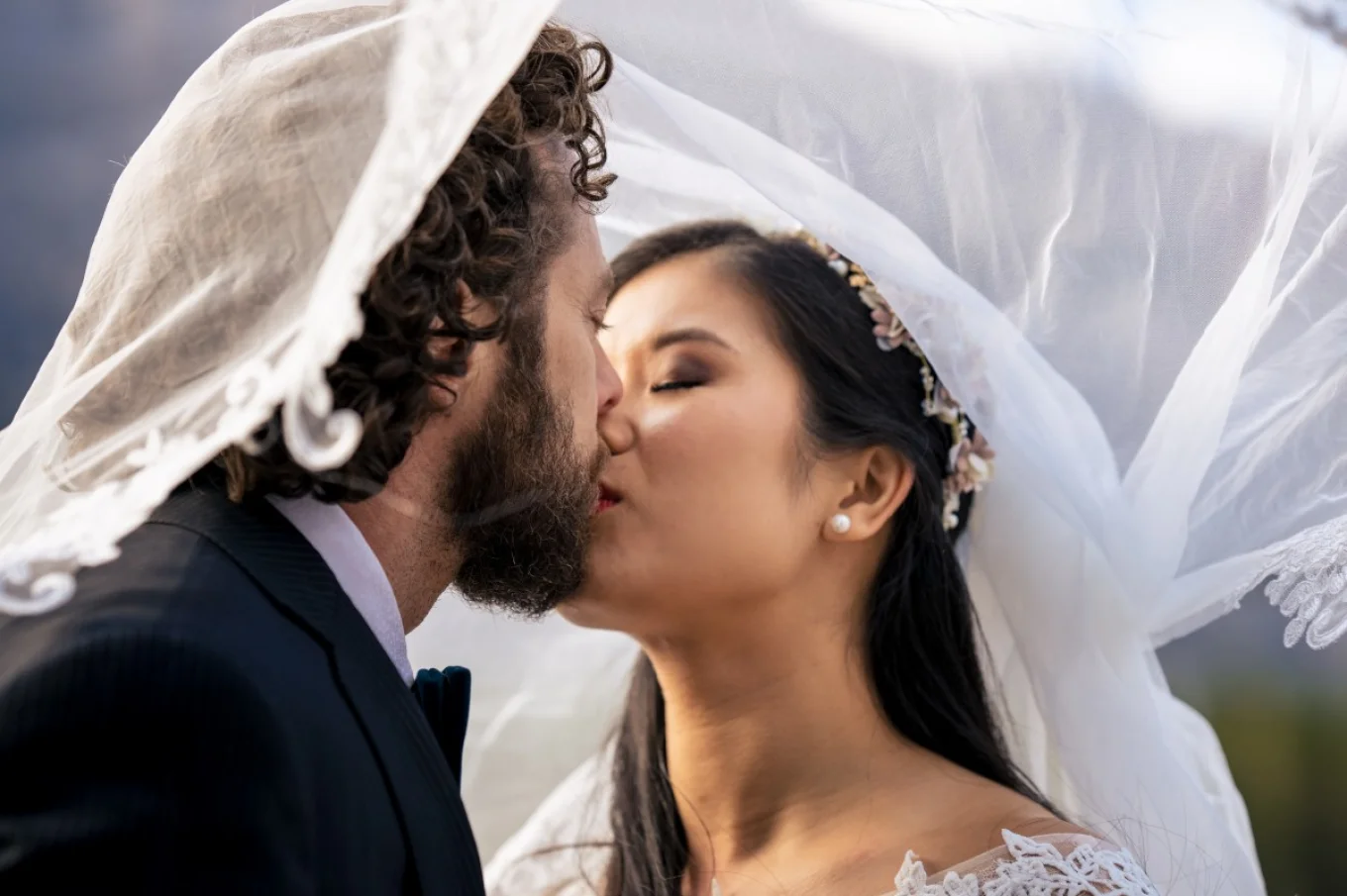 Newlyweds kissing under the veil.