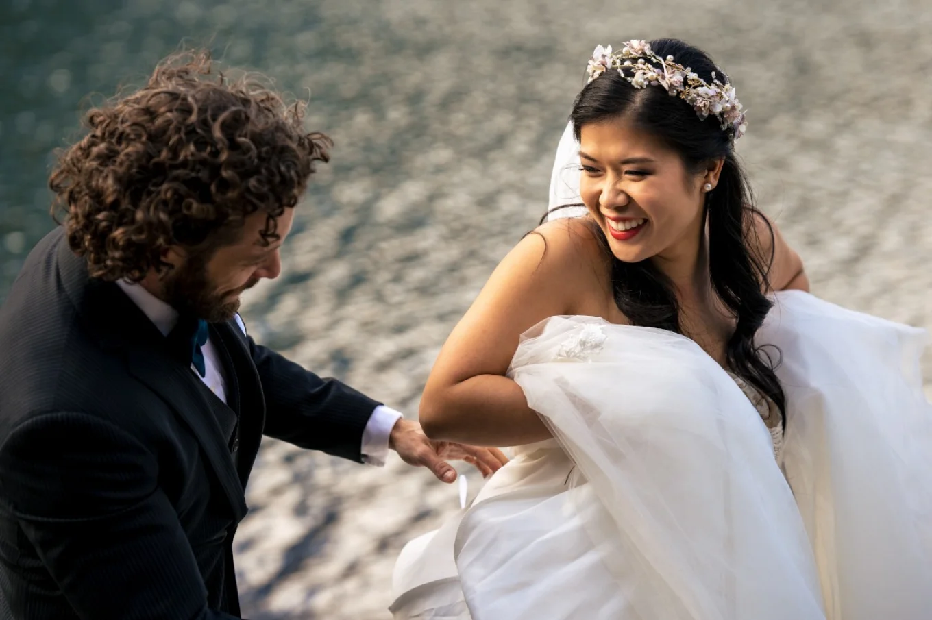 bride is lifting her wedding dress and lough to her husband