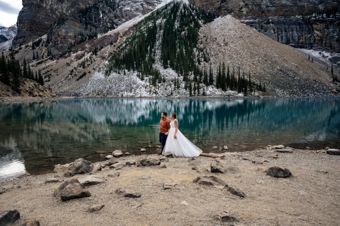 Bride and Groom walk down the blue Moraine Lake.