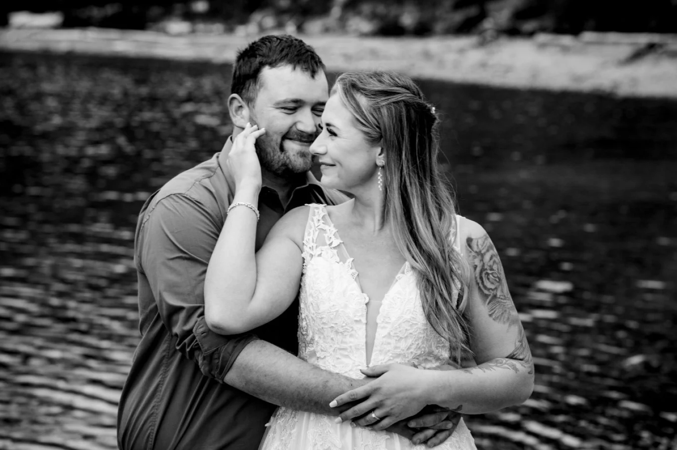 Groom whisper a secret into bride's ear. They both laugh.