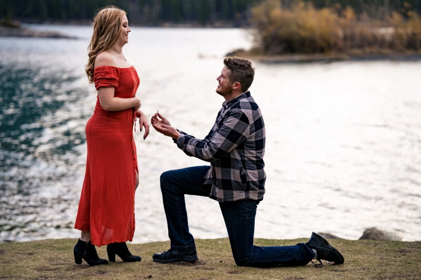 Handsome mad went down on his knee and propose his girlfriend. at Minnewanka Lake in Banff.