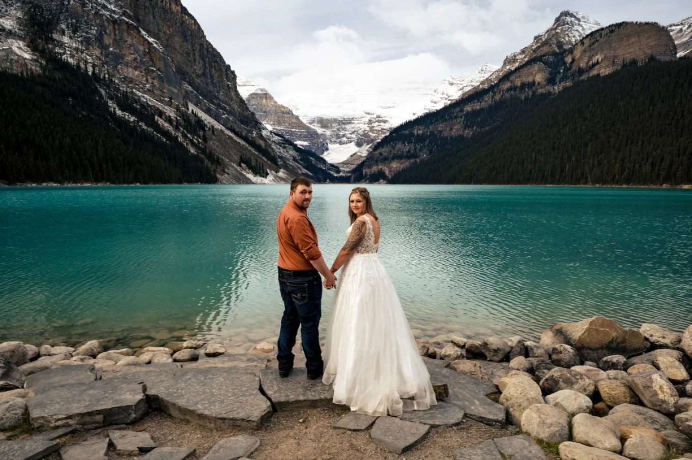 Newlyweds surprised by Calgary Wedding Photographer while adoring the beautiful, turquoise Lake Louise in Banff.