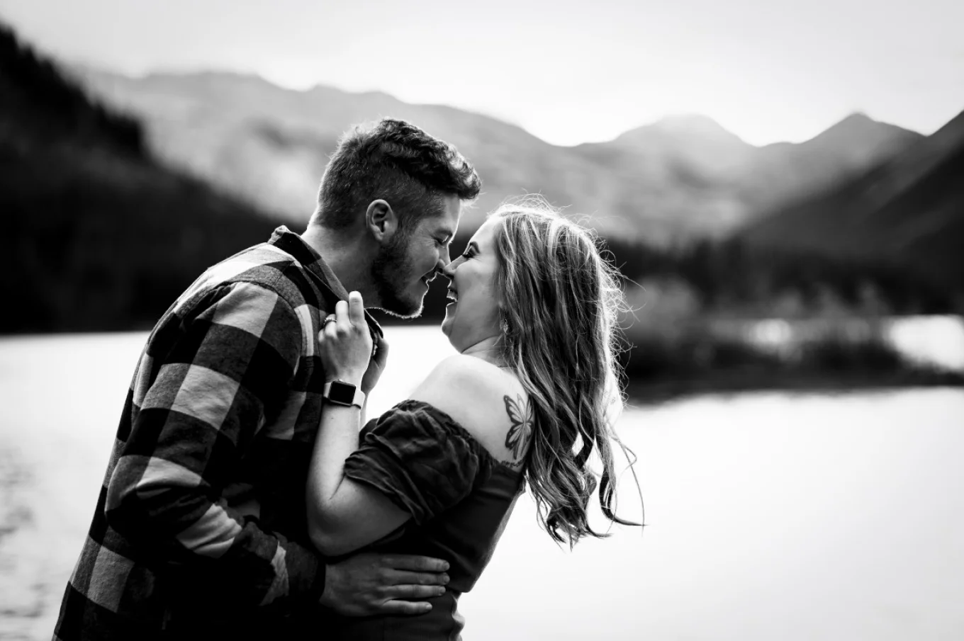 Happy freshly engaged couple give yourself chicken-kisses. They are touching their noses and laugh.