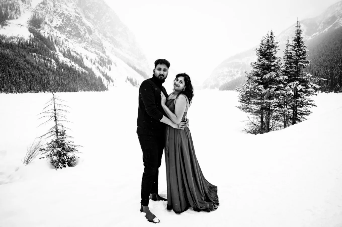 black and white photograph of couple in love. They look at the Calgary Wedding Photographer's camera and smile.