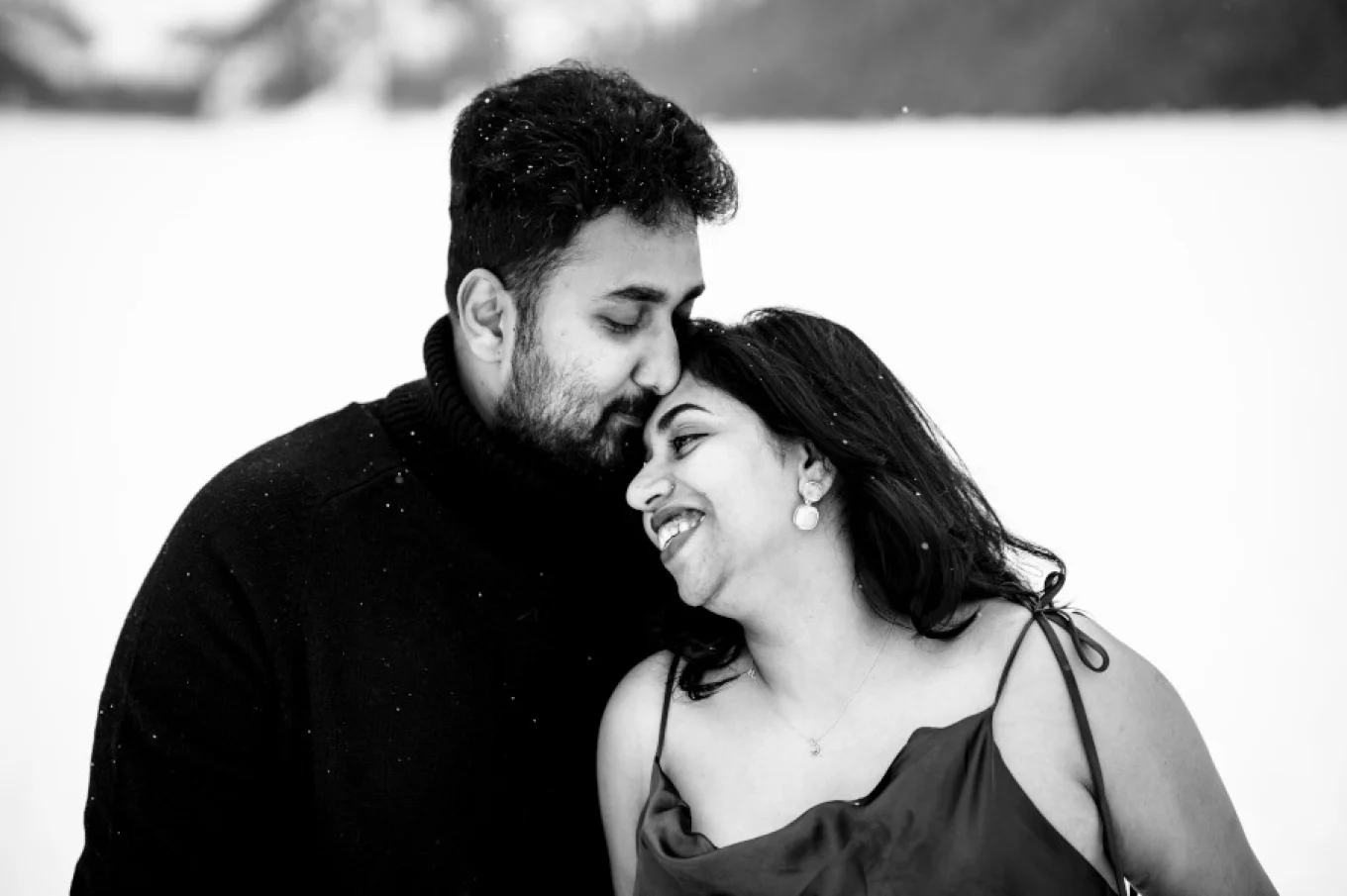 Men kisses his wife's forehead.