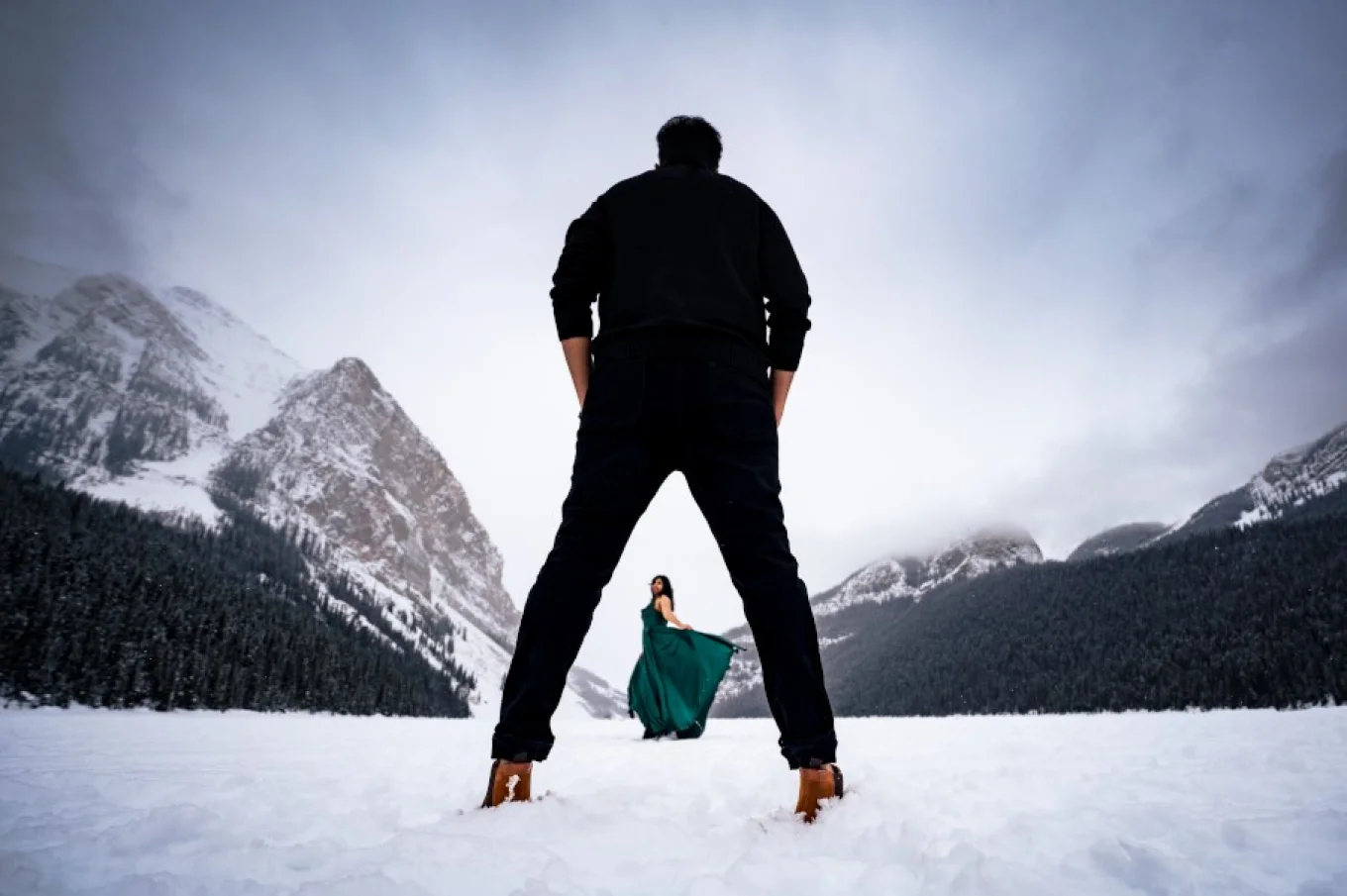 Gentlemen admire his wife dancing for him at t he frozen Lake Louise in Banff National Park.
