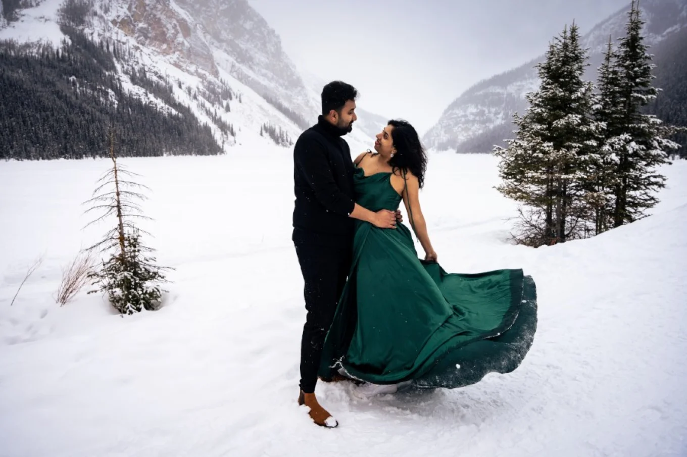 Indian, good dresses couple hug each other and look deeply into each other eyes. It is winter in the Canadian Rocky Mountains.